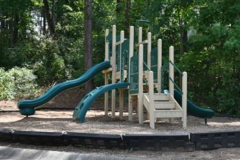 a playground with a set of slides in a park